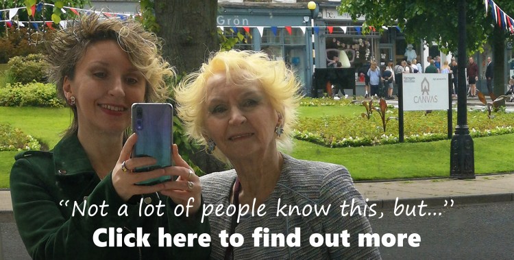 Image shows mother and daughter, Gwen Hullah and Ida Barker of She And The Cat's Mother smiling happily at the Queen's Platinum Jubilee Event 2022 on the streets of Spa Town, Harrogate. Text on image states: “Not a lot of people know this, but...” with a click here to find out more invite.